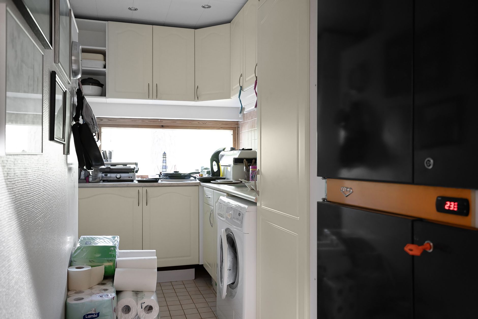 Narrow kitchen cabinet with neatly arranged storage containers and labeled shelves