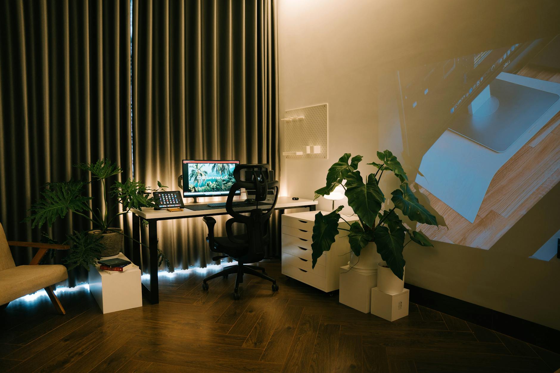 A cozy home office setup with a comfortable chair, desk, and plants