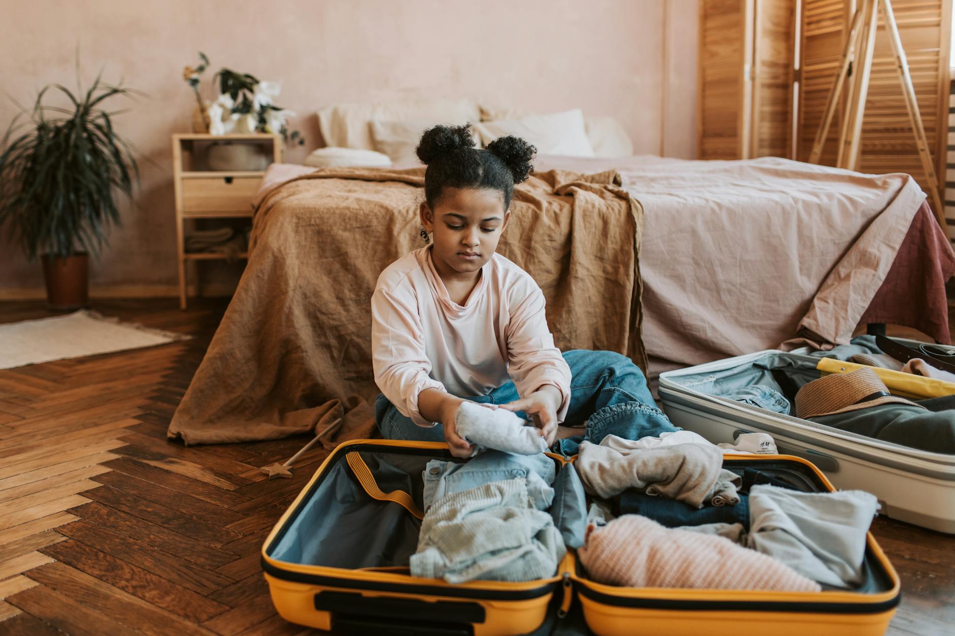 open travel bag with neatly packed reusable pouches on a bed